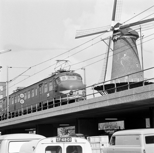 857530 Gezicht op de molen De Roos aan de Phoenixstraat te Delft, met op de voorgrond een electrisch treinstel mat. ...